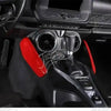 Interior view of a car's gear shift and surrounding trim components with red accents.