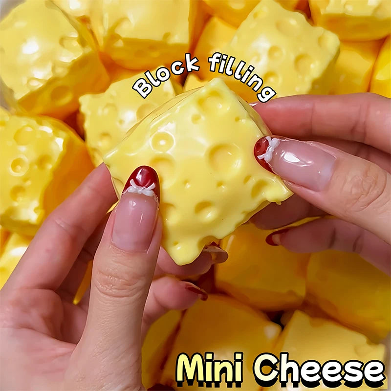 Hands are squeezing a yellow block filling mini cheese product.