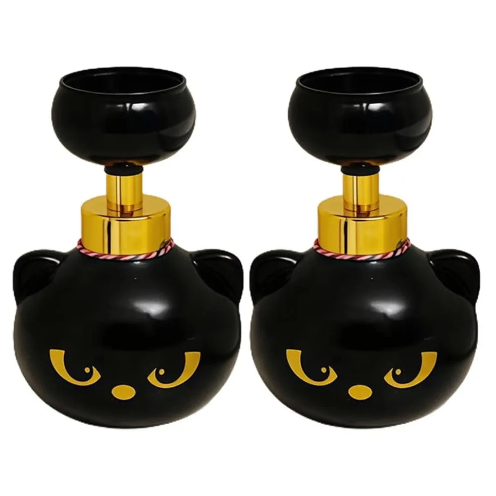 A pair of black and gold foam soap dispensers shaped like cat paws.