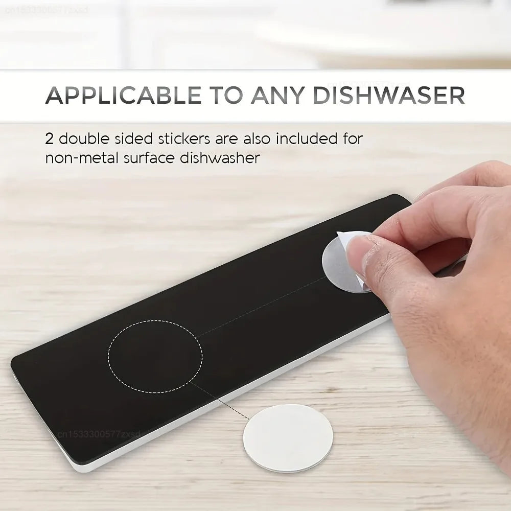A hand is applying a double-sided sticker to a black magnet sign designed for dishwasher and refrigerator use.