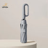 A silver fully automatic windproof folding umbrella standing upright on a light surface.