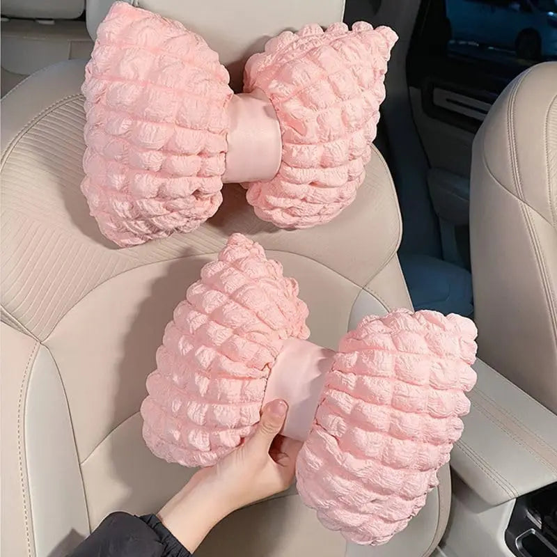 Pink bowknot car neck pillow with lumbar support shown in a car seat