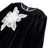 Black velvet fabric featuring a white floral lace applique patch on the shoulder