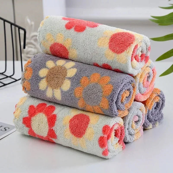A stack of colorful microfiber kitchen cleaning cloths featuring floral patterns in orange, pink, and gray.