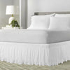 White ruffled elastic bed skirt covering a queen or king bed frame.