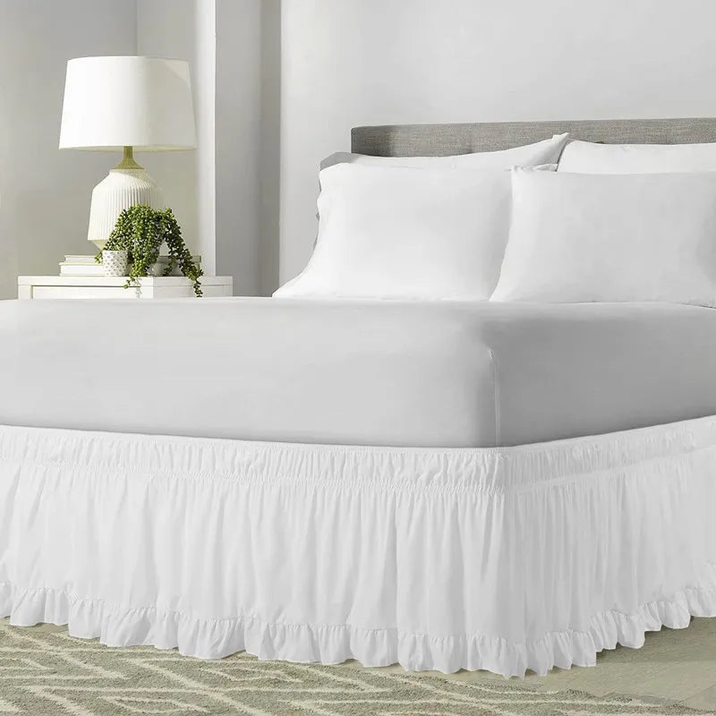 White ruffled elastic bed skirt covering a queen or king bed frame.