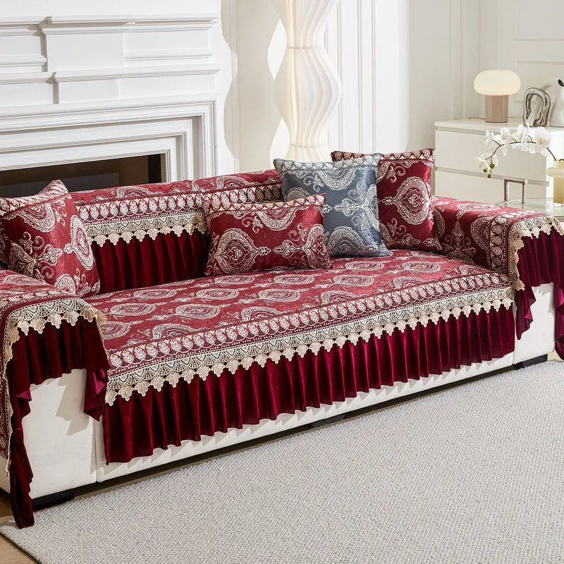 A deep red patterned sofa cover with quilted protection and decorative trim displayed on a white sofa.