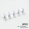 Five white reusable nail glue clay posts arranged in a row on a clear acrylic shelf.