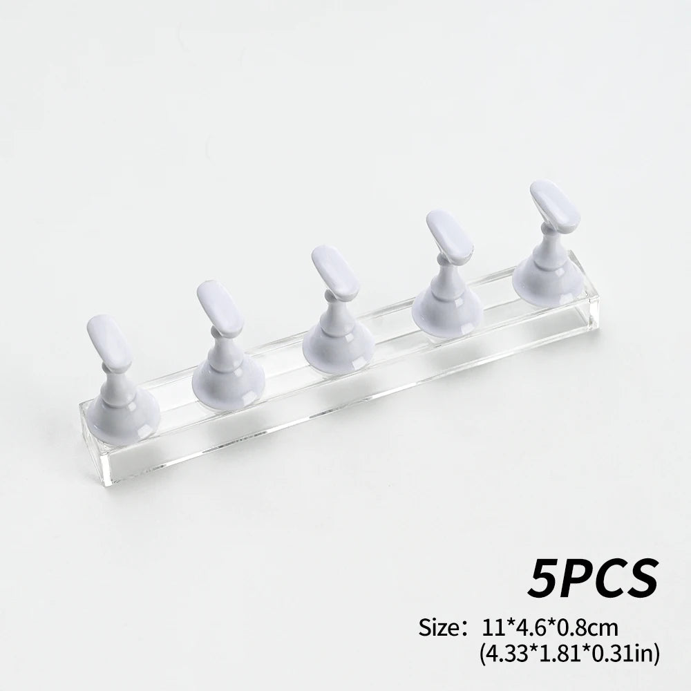 Five white reusable nail glue clay posts arranged in a row on a clear acrylic shelf.