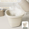 A white collapsible portable bucket being filled with water, demonstrating its odor-free and multipurpose use.