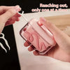 A hand is using a portable automatic floss pick dispenser with a white tool to extract floss.