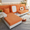 An orange and white modern sofa with a textured slipcover and light wood accents in a bright living room.