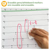 A hand is using a pink erasable pen to write fractions on a number line poster for classroom math learning.