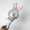 A plush rabbit head with pink ears and a clear dome featuring a watch, attached to a light stick cover.