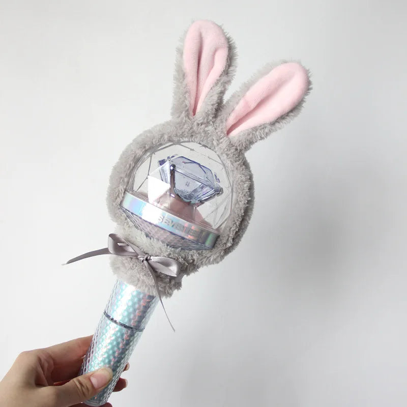 A plush rabbit head with pink ears and a clear dome featuring a watch, attached to a light stick cover.