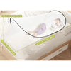 A child is lying on a bed with an instant pop-up mosquito net installed over the bedding.