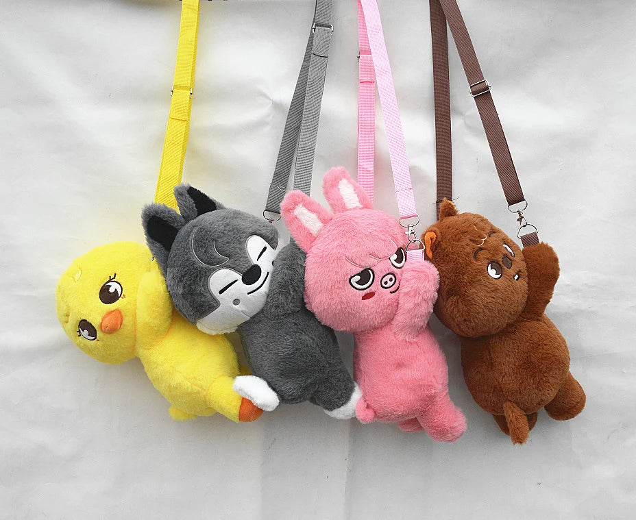 A collection of five soft stuffed animal plush dolls in yellow, gray, pink, and brown hanging from straps.