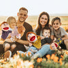 A family of five, including parents and three children, posing outdoors with soft hand puppets.