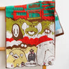 A hand-embroidered cartoon face towel featuring various animal and character faces in earthy tones.