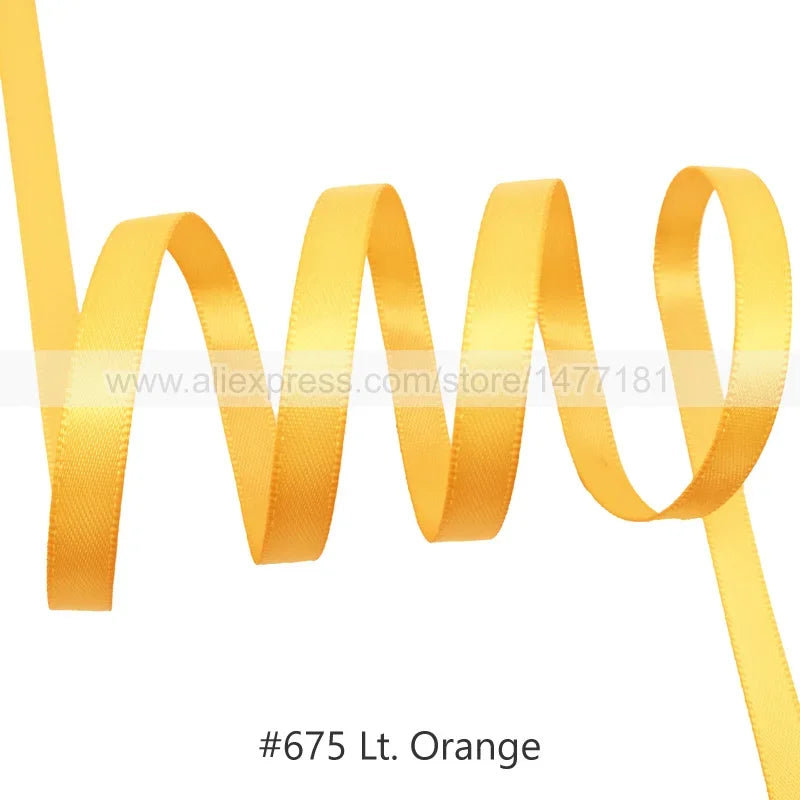 A roll of orange satin ribbon being unwound.