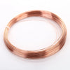 A coil of bare copper wire with multiple diameters laid out in a circular shape.