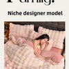 A pink faux fur bedding set is shown on a bed, featuring soft textures and warm tones.