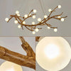 A chandelier featuring a branch-like light fixture with multiple small, glowing spherical bulbs.