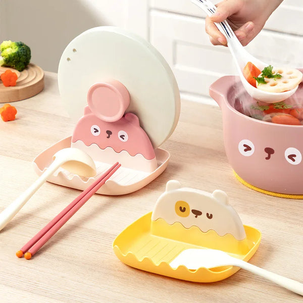 A set of pink and yellow silicone pot lids and utensil organizers for cooking and serving.