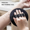 A hand is using a black mud rubbing tool on its wrist to exfoliate the skin.