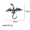 A silver enamel dragon brooch with green and blue rhinestone accents.