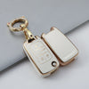 A gold-toned protective TPU key fob cover for a vehicle, shown against a light gray background.