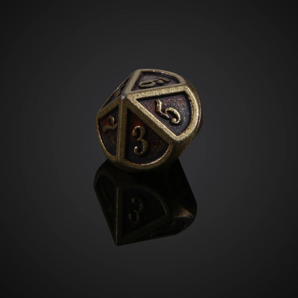 A bronze metal polyhedral die showing the number 3, resting on a reflective surface.