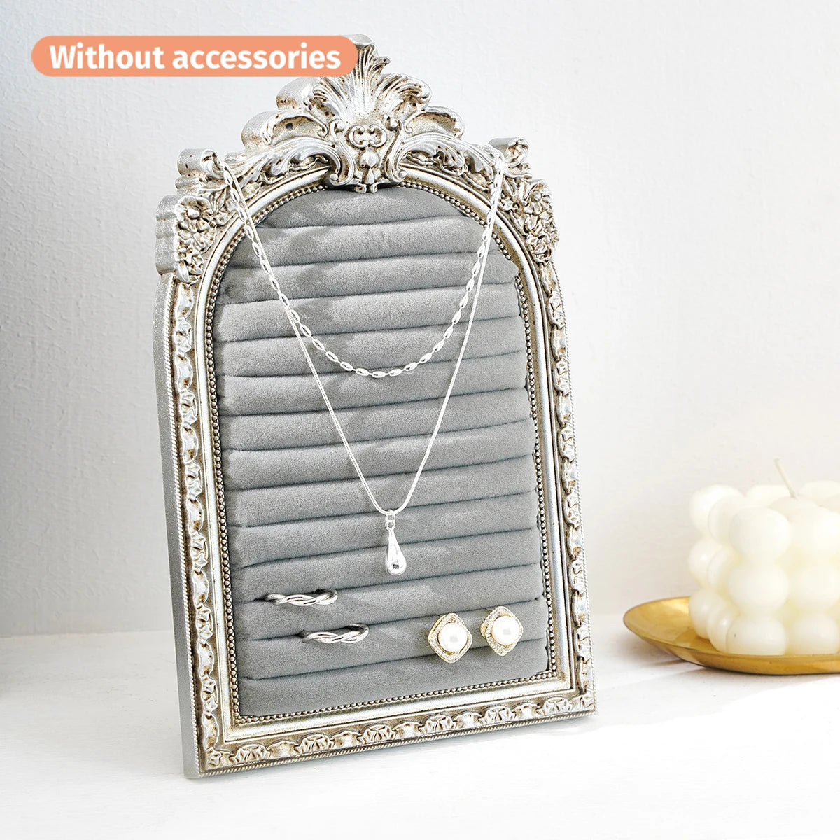 Silver arched resin jewelry display stand with a floral design featuring a silver necklace and earrings.