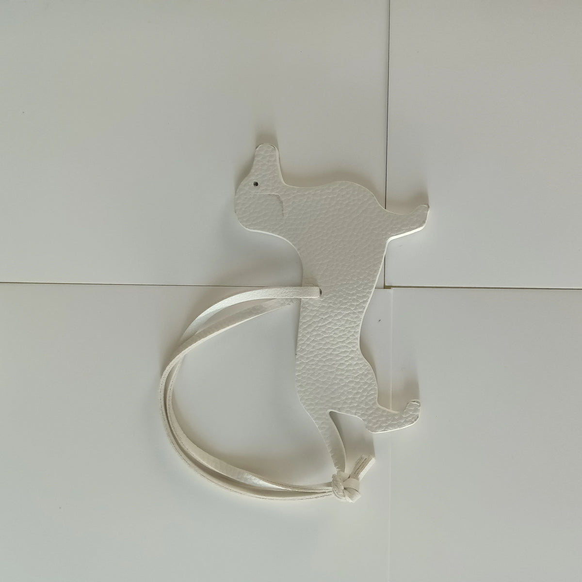 A white PU leather keychain shaped like a dachshund and bulldog.