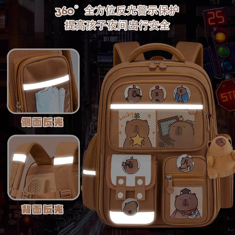 A tan backpack for children featuring 360-degree light protection and ergonomic support, decorated with capybara characters.
