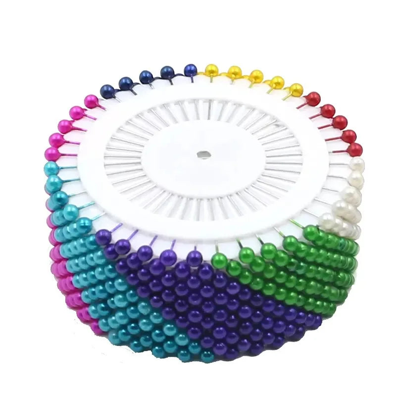 Colorful round pearl straight pins arranged in a circular pattern for sewing and crafts