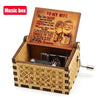 A vintage hand-crank wooden music box with an engraved lid featuring the text You Are Braver Than You Believe and a smiling i