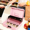 A pink lockable cash box with an open tray displaying various coins and bills, being handled by a person.