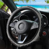 A close-up view of a black steering wheel with a faux sheepskin leather cover inside a car interior.