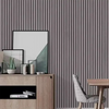 A display of framed art and decorative items on a wooden cabinet against a vertical slat wall.