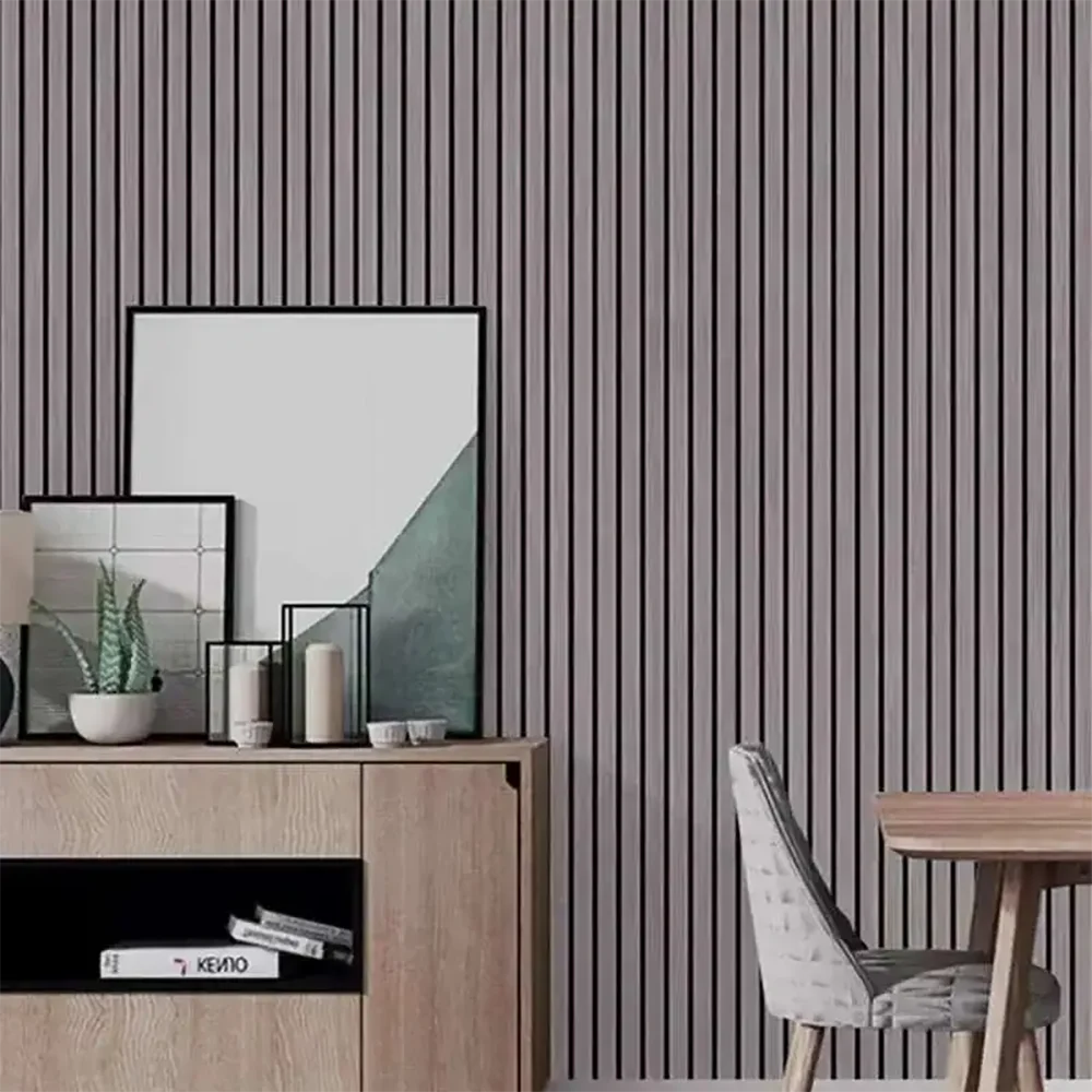 A display of framed art and decorative items on a wooden cabinet against a vertical slat wall.