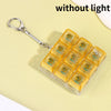 A clear plastic case filled with yellow LED mechanical keychain fidget toys, shown against a light yellow background.