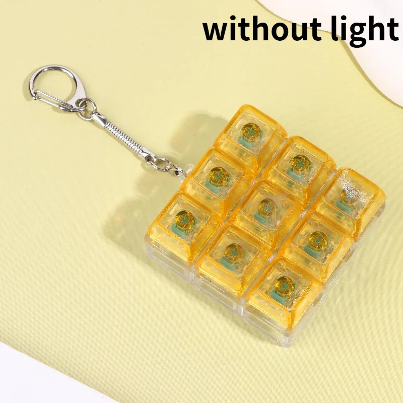 A clear plastic case filled with yellow LED mechanical keychain fidget toys, shown against a light yellow background.