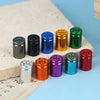 A set of four colored bullet shell tire valve stem caps arranged in a row on a light surface.