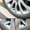 Close-up view of aluminum alloy tire valve caps inserted into a car wheel rim.