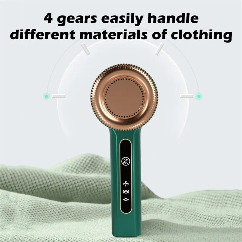 A green electric lint remover device with a copper-colored lint roller is shown resting on a light green fabric.