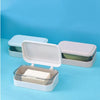 A white transparent soap dish with a drainage tray is shown on a light blue background.