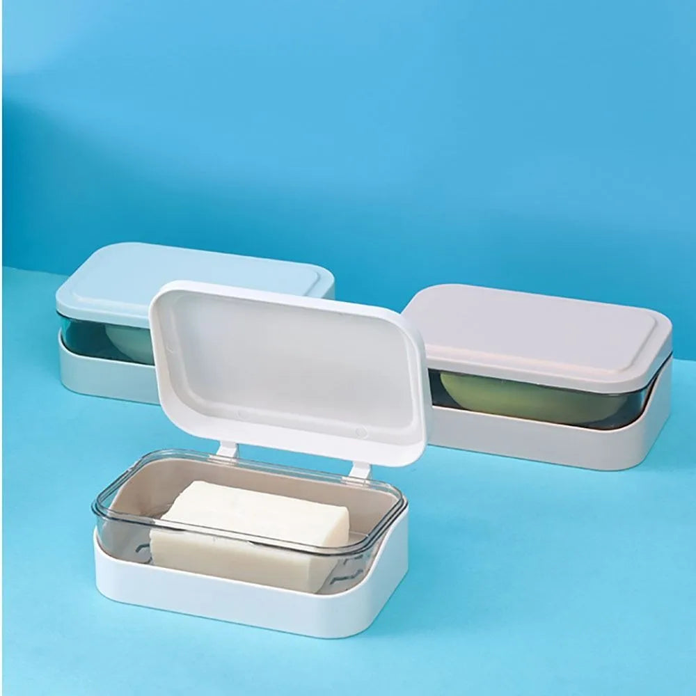 A white transparent soap dish with a drainage tray is shown on a light blue background.