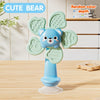 A light blue cute bear spinning toy with green wings and a suction cup base on a wooden table.