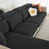 A dark gray jacquard elastic sofa slipcover with orange and white accent pillows.